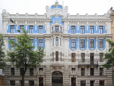 Façade of symmetrical building with horizontal lines and many geometric patterns.