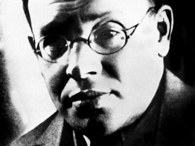 Photograph of man wearing glasses and suit.