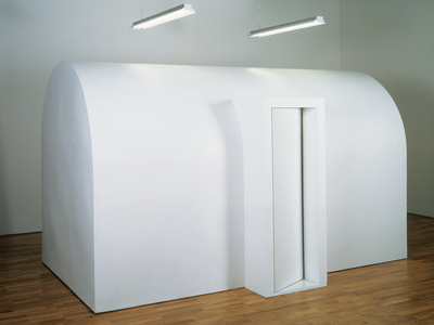 Art installation of large wooden domed structure with curved doorway. 
