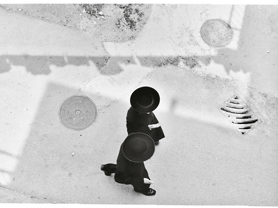 Aerial photograph of two people in hats and suits walking.