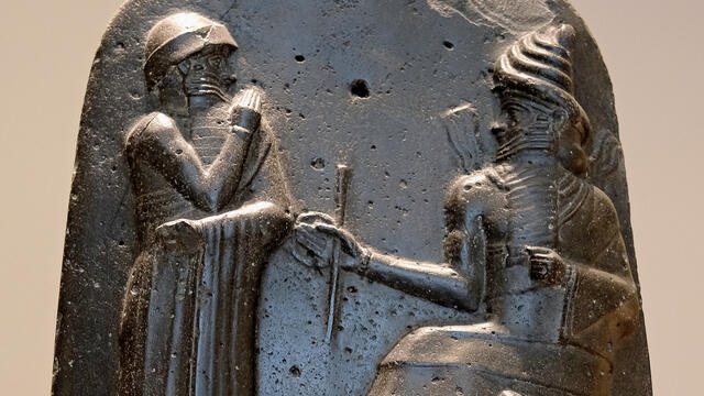 Hammurabi detail The top of Hammurabi's Stela; Hammurabi stands with a hand to his nose in submission to the seated god Shamash.