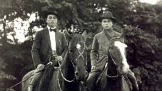 Jewish Gauchos Two men wearing jackets and hate are seated on horses.