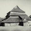 Photograph of wooden building exterior with several layers of roofs.