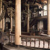Photograph of room with raised central platform with columns and several chandeliers.