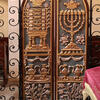 Set of curved doors with carving of candelabrum, peacock-shaped vessels, and basket of fruit and flowers on right side and table with compartments, peacock-shaped vessels, and basket of fruit and flowers on left side. 