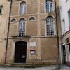 Exterior photograph of building facade with arched windows. 